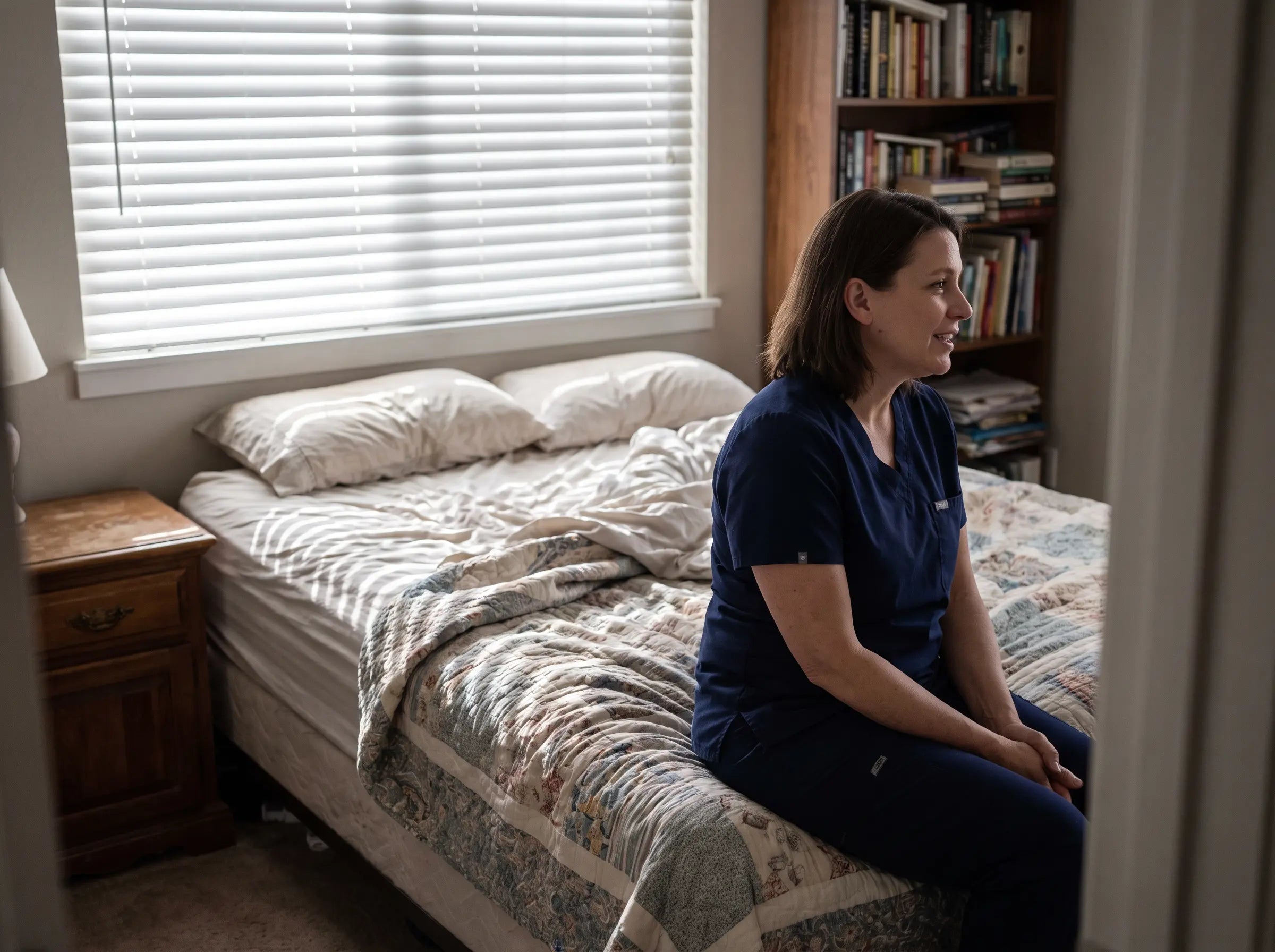 A midwife or doula mid-conversation in a bedroom